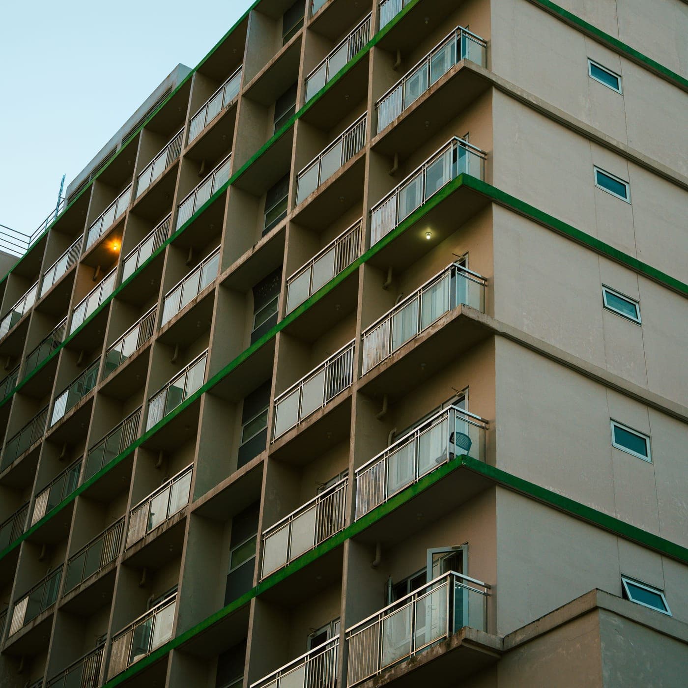 Apartment block facade with rows of balconies and green trim
